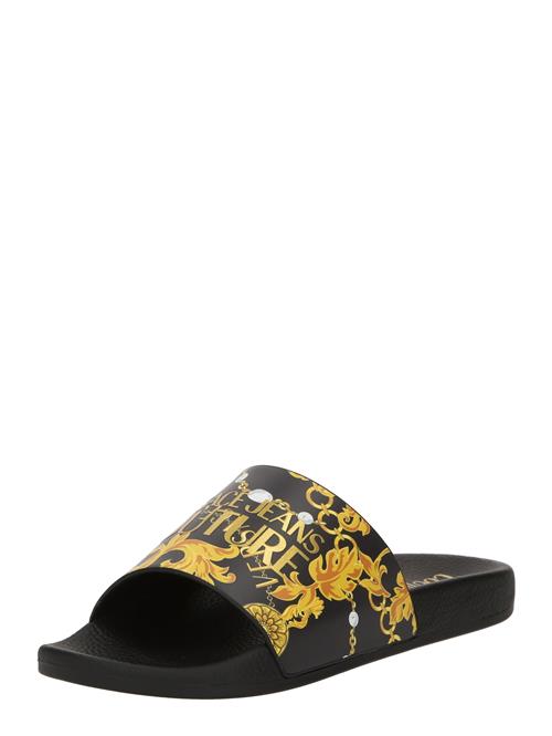 Se Versace Jeans Couture Pantoletter 'FONDO SHELLY'  gylden gul / safran / guld / sort ved About You